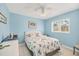 Bedroom with blue walls, white trim, a ceiling fan, and a large window bringing in natural light at 6345 Bodmin Ln, North Port, FL 34291