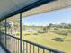 Screened balcony offering serene views of a pond surrounded by lush greenery and palm trees at 6800 Placida Rd # 272, Englewood, FL 34224