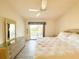 Bright bedroom with wicker furniture, light-colored floor, and a sliding glass door to a balcony at 6800 Placida Rd # 272, Englewood, FL 34224
