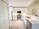 Modern kitchen with stainless appliances, bright white cabinets, and an open serving counter at 6800 Placida Rd # 272, Englewood, FL 34224