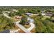 Aerial view of a single-Gathering home featuring a circular driveway, mature trees and screened-in pool at 7328 Yardley St, Englewood, FL 34224