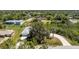 Aerial view of single-Gathering home with long driveway, and mature trees in a residential neighborhood at 7328 Yardley St, Englewood, FL 34224