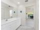 Well-lit bathroom with large mirror and view to lanai at 7328 Yardley St, Englewood, FL 34224