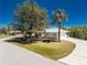 Street view of the house with large trees and a circular driveway at 7328 Yardley St, Englewood, FL 34224