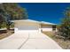 Single-story home featuring a well-maintained lawn, a two-car garage, and a concrete driveway at 7328 Yardley St, Englewood, FL 34224