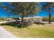 Charming single-story home with a well-manicured lawn, mature trees, and a two-car garage at 7328 Yardley St, Englewood, FL 34224
