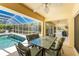 Covered patio with dining table and chairs overlooking a screened-in pool area at 7328 Yardley St, Englewood, FL 34224