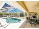 View of the screened-in pool and enclosed patio with dining area at 7328 Yardley St, Englewood, FL 34224