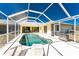 Screened-in pool area with lounge chairs, grill, and a view of the home's exterior at 7328 Yardley St, Englewood, FL 34224