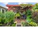 Cozy brick patio with pergola, lush tropical landscaping, string lights, and comfortable seating creating a tranquil retreat at 7339 Thomas St, Englewood, FL 34224