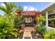 Tranquil backyard brick patio with a pergola, comfortable seating, lush foliage, and decorative elements at 7339 Thomas St, Englewood, FL 34224
