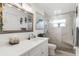 Bright and modern bathroom featuring a walk-in shower, vanity with large mirror and a linen cabinet at 7339 Thomas St, Englewood, FL 34224