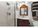 Bathroom showcasing a tiled shower with glass door and a decorative vanity with a framed mirror at 7339 Thomas St, Englewood, FL 34224