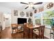 Cozy dining area featuring a table with seating for four, a ceiling fan and views of the front yard at 7339 Thomas St, Englewood, FL 34224
