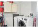 Bright laundry room featuring a modern, front-load washer and dryer and overhead storage cabinets at 7339 Thomas St, Englewood, FL 34224