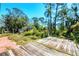 Spacious backyard showcasing a wooden deck and lush greenery, ideal for outdoor entertaining and relaxation at 745 Sesame St, Englewood, FL 34223