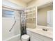 Bright bathroom featuring a shower-tub combination with decorative shower curtain and built-in shelving at 745 Sesame St, Englewood, FL 34223