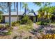 Well-kept home exterior featuring mature palm trees and tropical plants in a lush yard at 745 Sesame St, Englewood, FL 34223