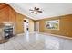 Bright living room with tile flooring, a stone fireplace, a ceiling fan, and ample natural light at 745 Sesame St, Englewood, FL 34223