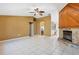 Open living room with a stone fireplace, tile flooring, and a ceiling fan, perfect for relaxation at 745 Sesame St, Englewood, FL 34223