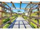 Picturesque backyard scene featuring a wooden walkway leading to the house through lush greenery at 745 Sesame St, Englewood, FL 34223