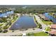 Aerial view of a pond surrounded by houses and lush greenery at 8784 Mystic Cir, North Port, FL 34287
