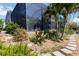 Backyard of the house featuring a screened lanai and landscaped gardens at 8784 Mystic Cir, North Port, FL 34287