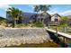 Beautiful waterfront home featuring a screened lanai, wooden dock, and lush tropical landscaping at 8784 Mystic Cir, North Port, FL 34287