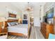 Stylish bedroom featuring a tropical ceiling fan, wood furniture, and an open entry to the bathroom at 8784 Mystic Cir, North Port, FL 34287