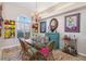 Bright dining room featuring a glass table, wicker chairs, shutters, and colorful artwork at 8784 Mystic Cir, North Port, FL 34287