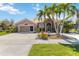 Inviting single-story home with lush landscaping and swaying palm trees for tropical curb appeal at 8784 Mystic Cir, North Port, FL 34287