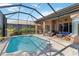 Screened pool area features outdoor seating and beautiful views from this backyard oasis at 8784 Mystic Cir, North Port, FL 34287