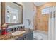 Quaint bathroom with granite counters, framed mirror, and tiled tub and shower at 9 Peekins Cove Dr, Boca Grande, FL 33921