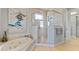 Elegant bathroom with a soaking tub, glass shower, and attractive artistic decor at 9 Peekins Cove Dr, Boca Grande, FL 33921