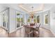 Bright dining room with a stylish chandelier, french doors, and a tray ceiling with accent lighting at 9 Peekins Cove Dr, Boca Grande, FL 33921