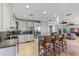 Modern kitchen featuring white cabinetry, stainless steel appliances, a breakfast bar with seating, and stylish lighting at 9 Peekins Cove Dr, Boca Grande, FL 33921