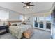 Serene main bedroom with water view, ceiling fan, balcony access, and woven bench at 9 Peekins Cove Dr, Boca Grande, FL 33921