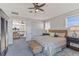 Stylish main bedroom showcasing a ceiling fan, balcony access, and woven bench at 9 Peekins Cove Dr, Boca Grande, FL 33921