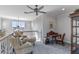 Cozy sitting room with a ceiling fan, carpet, two chairs, an ottoman, and a desk at 9 Peekins Cove Dr, Boca Grande, FL 33921