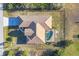 This home features an aerial view showcasing the roof, screened in pool, driveway and yard at 9219 Newnan Cir, Port Charlotte, FL 33981