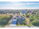 An aerial view of a single-story home in a quiet neighborhood surrounded by lush greenery at 9219 Newnan Cir, Port Charlotte, FL 33981