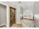 Bathroom with tiled shower and separate soaking tub under an arched window at 9219 Newnan Cir, Port Charlotte, FL 33981