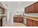 Open concept kitchen with granite counters, stainless steel appliances, and cherry wood cabinets at 9219 Newnan Cir, Port Charlotte, FL 33981