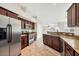 Charming kitchen features stainless steel appliances, granite counters, and cherry wood cabinets at 9219 Newnan Cir, Port Charlotte, FL 33981