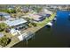 An aerial view shows a waterfront property with a boat lift, pool, lush yard and serene surroundings at 9330 Migue Cir, Port Charlotte, FL 33981