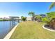 Enjoy the outdoors from this grassy backyard with boat dock, mature palms, and canal views at 9330 Migue Cir, Port Charlotte, FL 33981