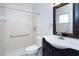 Clean bathroom featuring a tiled shower, grab bar, and vanity with dark cabinets at 9330 Migue Cir, Port Charlotte, FL 33981