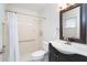 Clean bathroom featuring a tiled shower, grab bar, and vanity with dark cabinets at 9330 Migue Cir, Port Charlotte, FL 33981