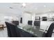 Bright dining area featuring a glass table and views into the living room and modern white kitchen at 9330 Migue Cir, Port Charlotte, FL 33981