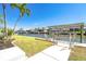 Waterfront property featuring a private dock with boat lift and access to scenic waterways under clear blue skies at 9330 Migue Cir, Port Charlotte, FL 33981